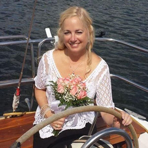 Picture of Angela Butler, a specialty credentialed respiratory care practitioner, at the helm of her boat