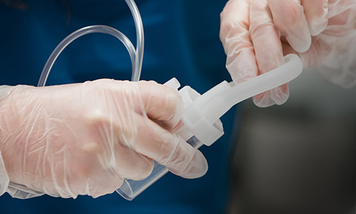 Close-up of respiratory therapist's hands holding respiratory equipment